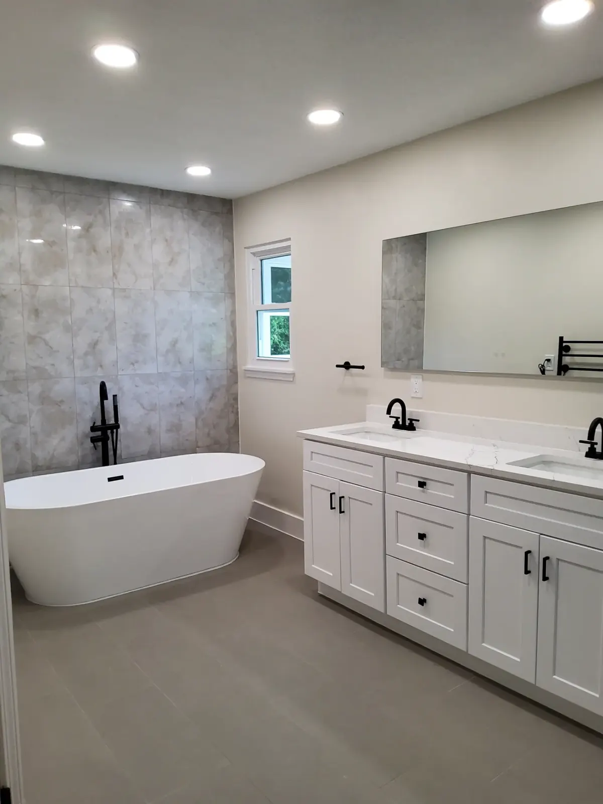 Bathroom after MSS renovation, with a freestanding tub, tiled shower wall, and a new double vanity